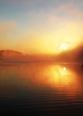 The sun rises through mist over a lake in the Appalachi ... 