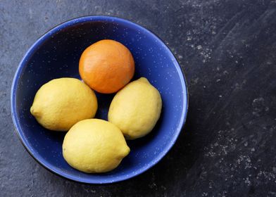 The Odd One Out Lemons and an Orange in a blue bowl