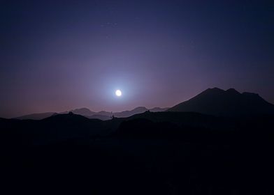 moonlight and mountains in silhouette
