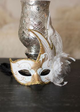 Mardi Gras mask with silver urn candle holder on my bla ... 