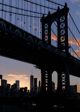 The Manhattan Bridge and the skyline are silhouetted on ... 