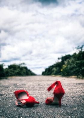 red high heels on a long rural road