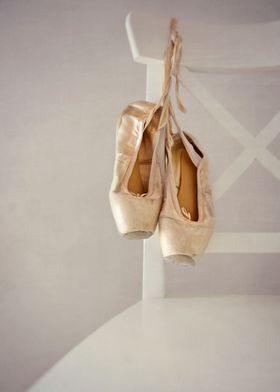 a pair of ballet shoes on a white chair 