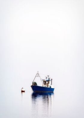 a fishing boat on a misty sea