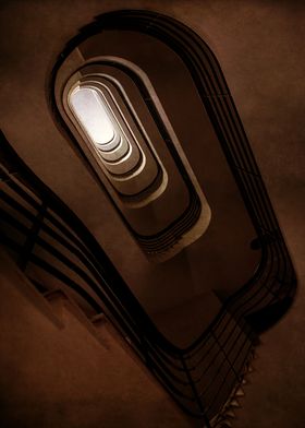 Oval staircase in brown tones. View from the bottom.
