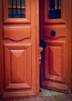 Girl in a Doorway. Little girl stands guard in Malta.