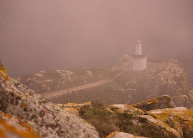 Curious light. Lighthouse at the end of a rocky path. C ... 