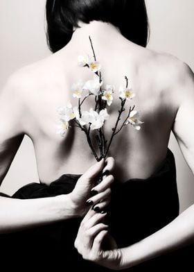 Skinny woman holding sakura flower on her back