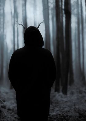 Man with antlers standing in the woods