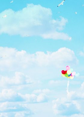 Rainbow colored balloon floating in a blue sky