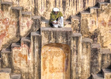 a man sitting in a stepwell in Jaipur, Rajasthan, India ... 