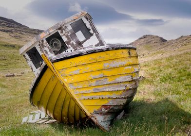 An old, ruined boat stuck on the land in Hofn, Iceland