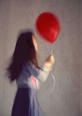 A blur girl holding a red ballon.