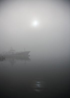 The sun peeking through the fog by the harbor in Tromsø ... 
