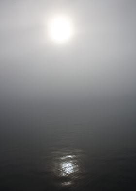 The sun peeking through the fog. Dimmed version. 