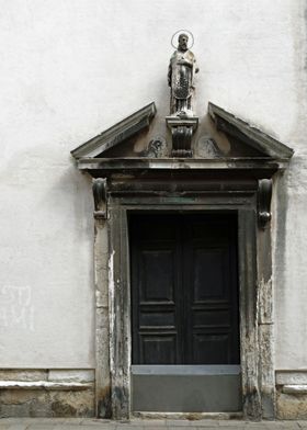 A religious statue sits atop an embellished doorway in  ... 