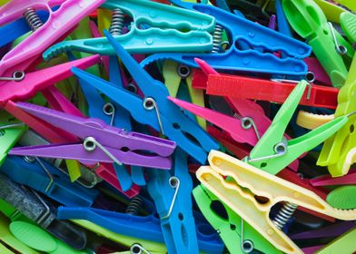 A jumble of various old plastic clothes pegs