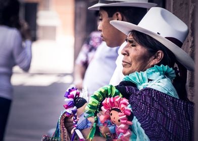 Mexican woman with traditional dress selling dolls