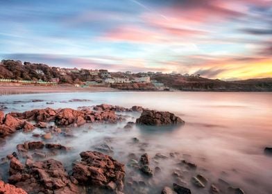 Small wooden chalets and a sunrise at Langland Bay