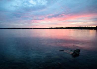 Pink Sky Reflection Over Clear Water at Sunset