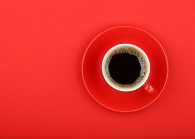 Cup of black coffee on red