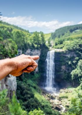 Hand pointing at waterfall