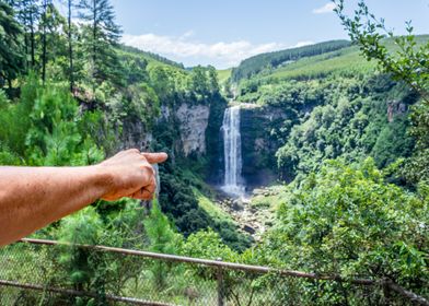 Man pointing at waterfall