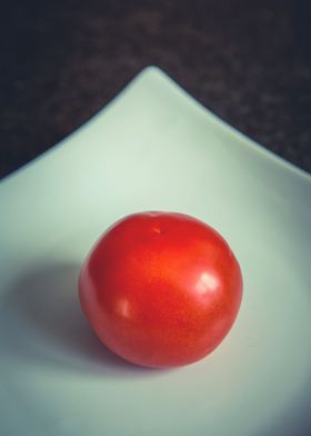 single red tomato in plate