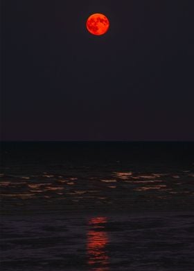 Red moon ocean waves