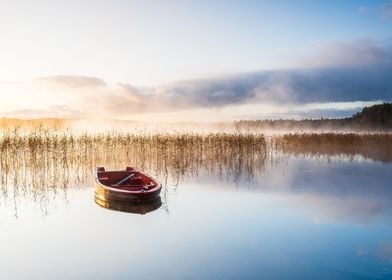 Red boat on misty lake