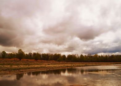 Cloudy autumn lake shore