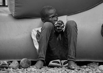 Young Boy Sitting by Inflatable Structure