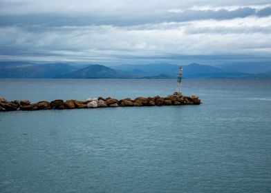 Coastal Lighthouse with Mountains