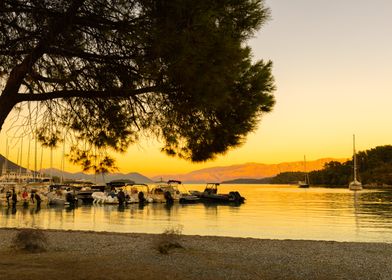 Boats from the port and summer sunset on a Greek island