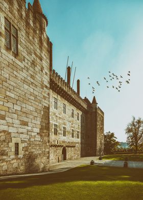 Guimaraes, Portugal. Palace of the Duques of Braganca. Medieval castle and museum of the Dukes of Braganza. Majestic stone castle with a towering facade constructed from rough-hewn stone blocks, giving it a weathered and ancient appearance.