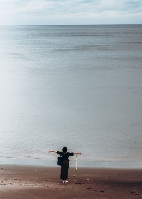 Woman on Beach with Arms Outstretched